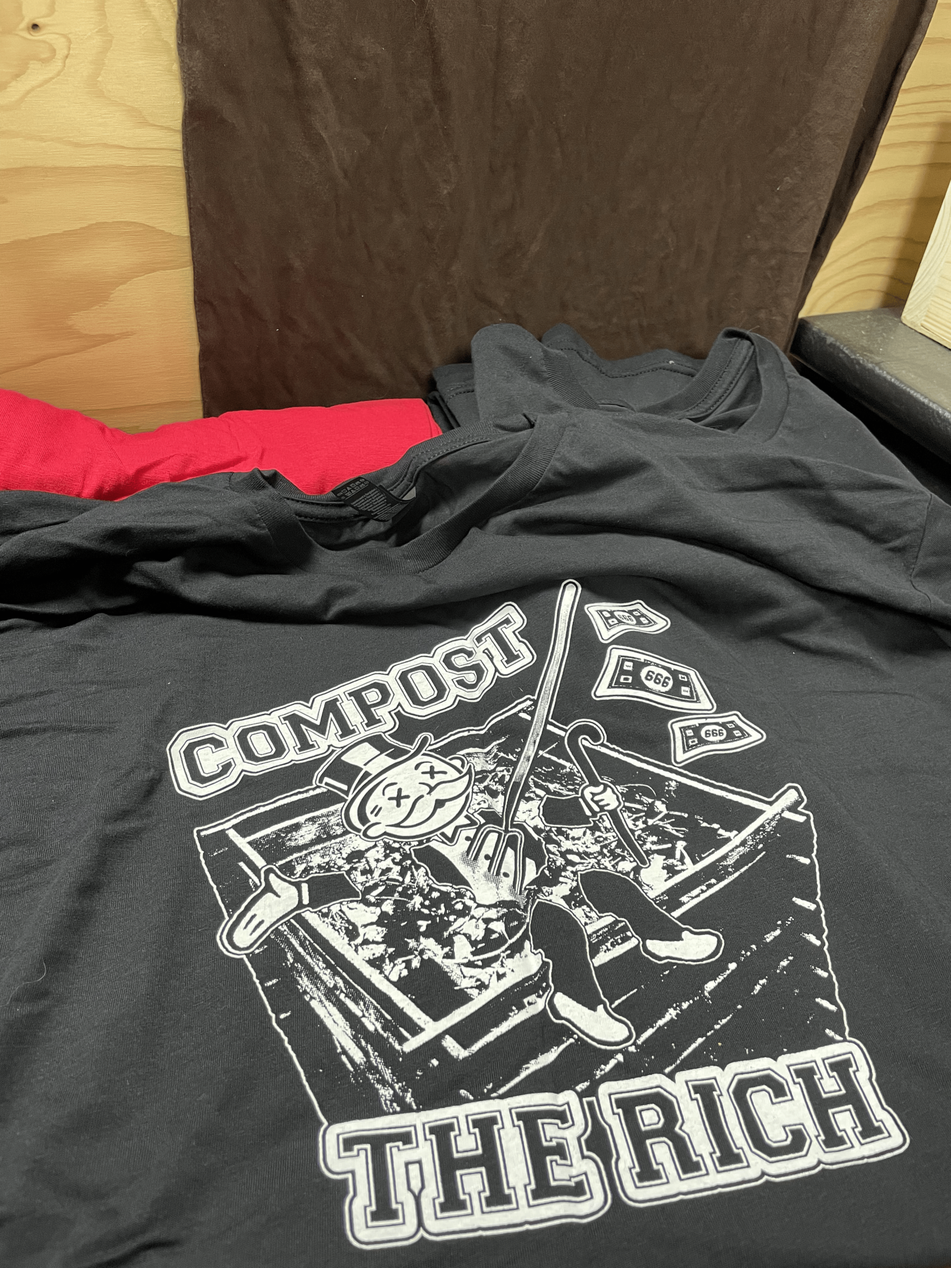 black t-shirt with the text: compost the rich